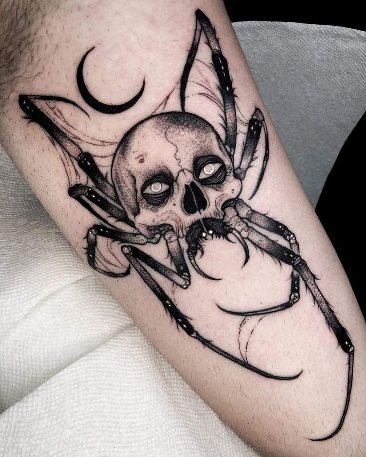 a skull and spider tattoo on the leg