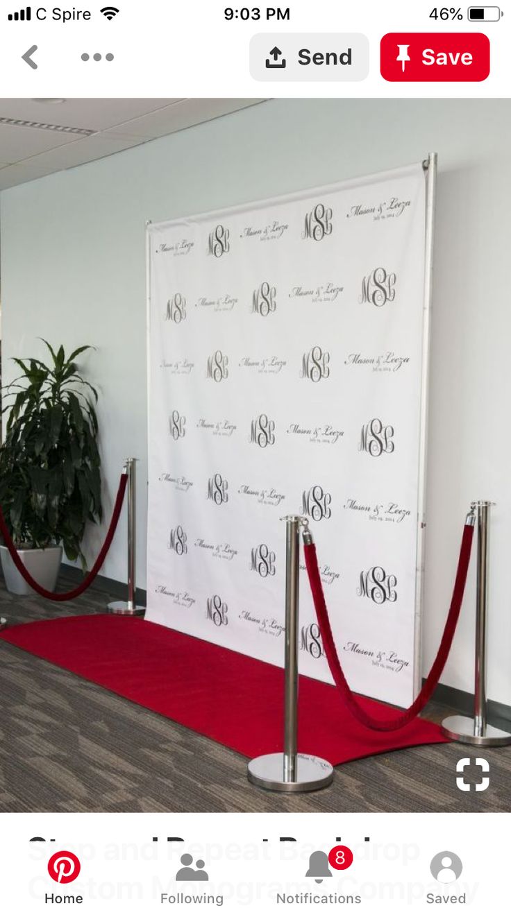 a red carpeted area with white backdrop and silver poles