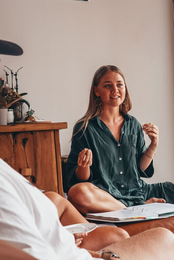 a woman sitting on top of a couch in front of a man who is doing yoga