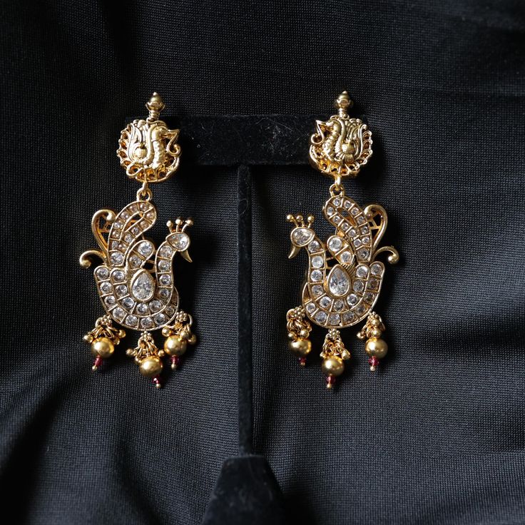 Brass alloy with white stonework. Product Dimensions (inches): L: 3 B: 1.5 H: 0.655 Traditional Metal Earrings For Formal Occasions, Gold Earrings With Stone Work, White Stone Work Earrings For Formal Occasions, Silver Jeweled Earrings For Festive Season, Formal Metal Jewelry With Stone Work, Elegant Silver Jeweled Danglers, Festive Hand Set Metal Earrings, Elegant Gold Jeweled Danglers, Silver Gold-plated Earrings With Stone Work