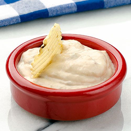 a red bowl filled with cream cheese on top of a table