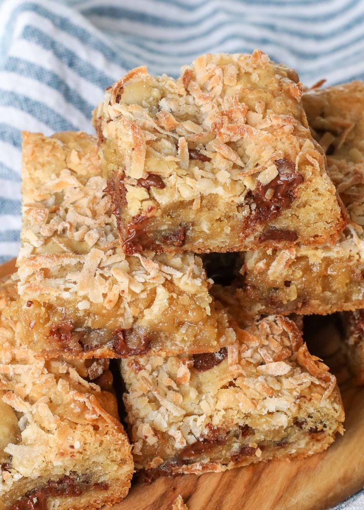 a wooden plate topped with granola bars on top of a blue and white towel