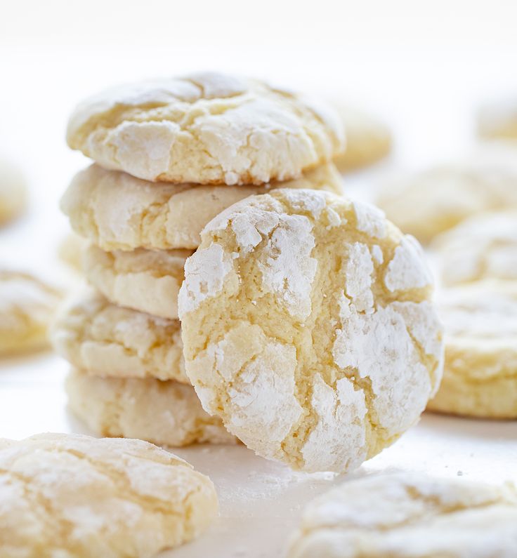 a stack of white powdered sugar cookies sitting on top of a table next to each other