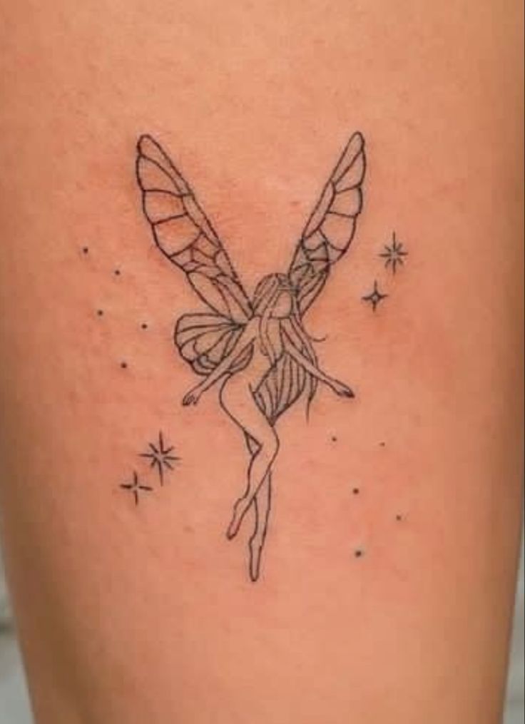 a woman's thigh with a small fairy tattoo on the side of her leg