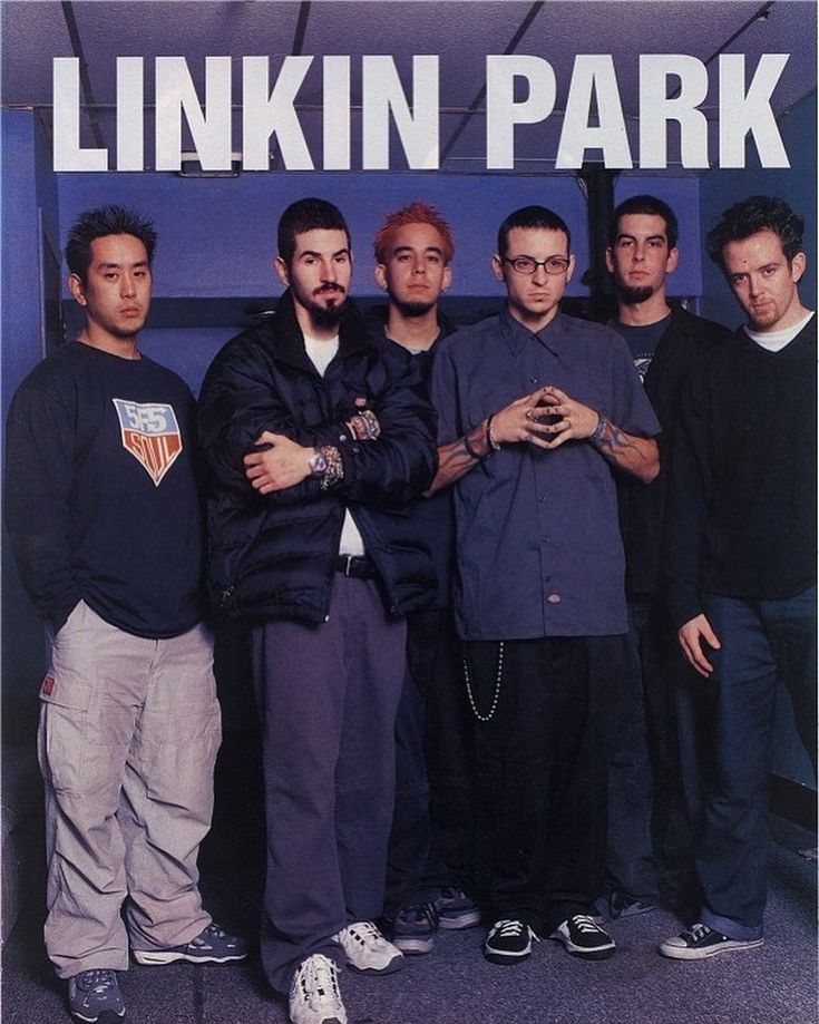 a group of men standing next to each other in front of a linkin park sign