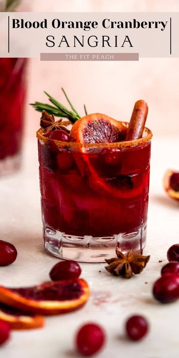 blood orange cranberry sangria in a glass garnished with an orange slice