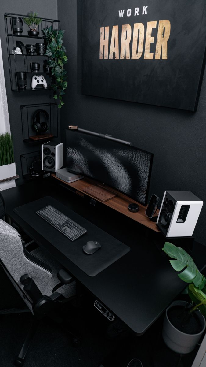 a computer desk with a monitor, keyboard and speakers on it in front of a work harder sign