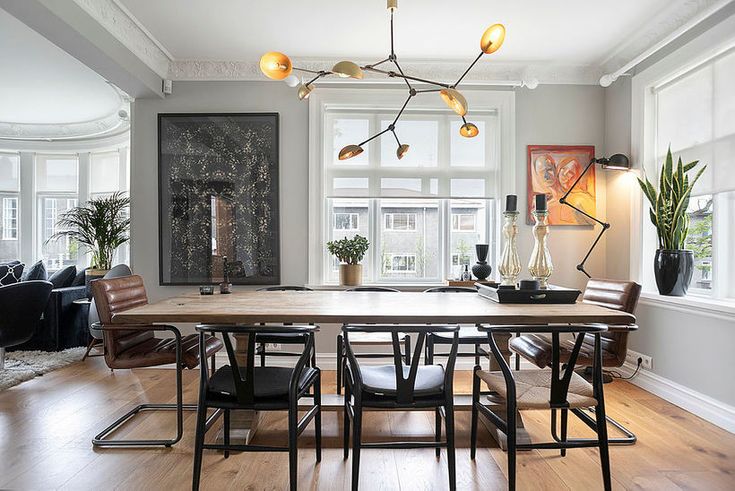 a dining room table surrounded by chairs and plants