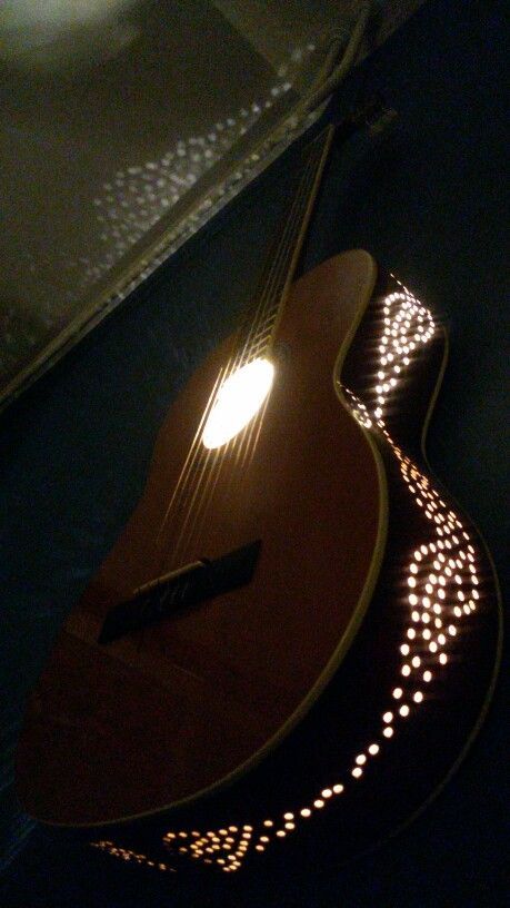 an illuminated guitar sitting on top of a table