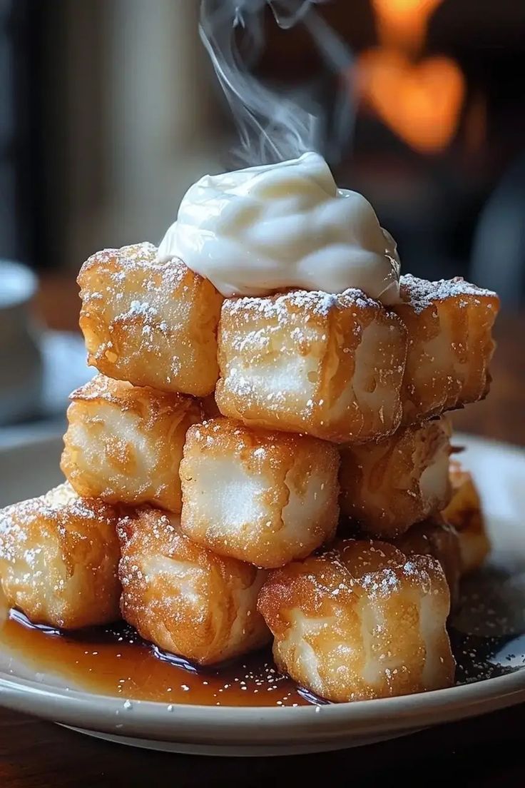 a stack of doughnuts sitting on top of a white plate covered in powdered sugar