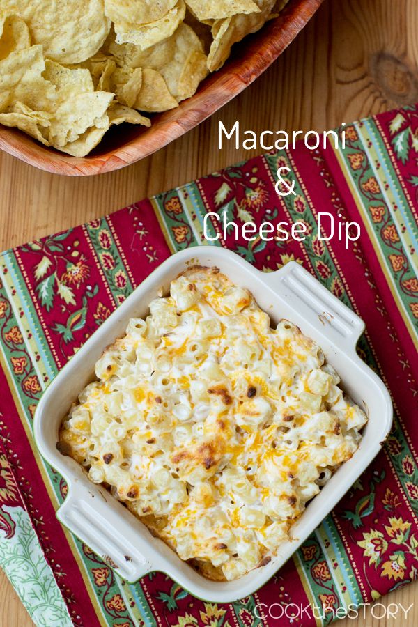 macaroni and cheese dip in a casserole dish next to a bowl of chips