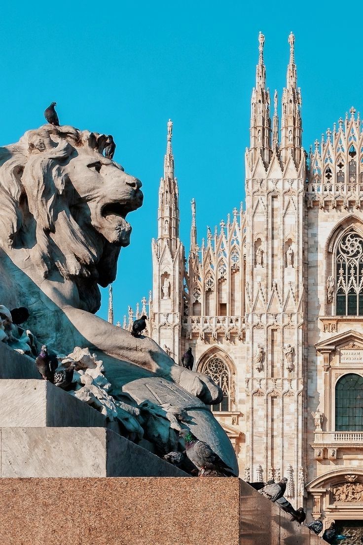 a statue of a lion in front of a cathedral