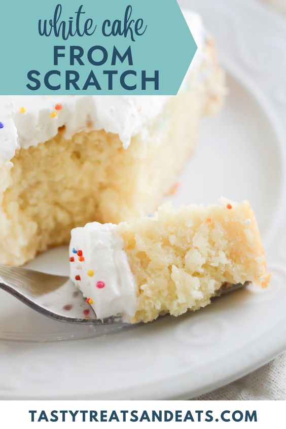 a piece of cake with white frosting and sprinkles on a plate