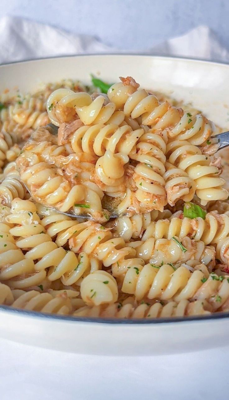 a white bowl filled with pasta covered in sauce