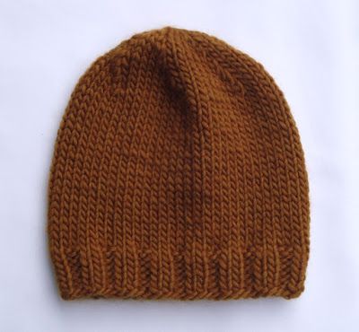 a brown knitted hat sitting on top of a white table