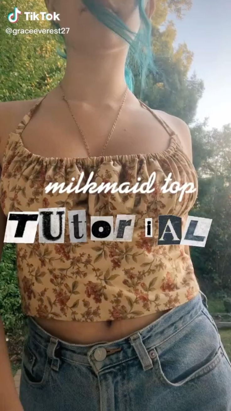 a woman with blue hair wearing a top that says,'millinandi stop '