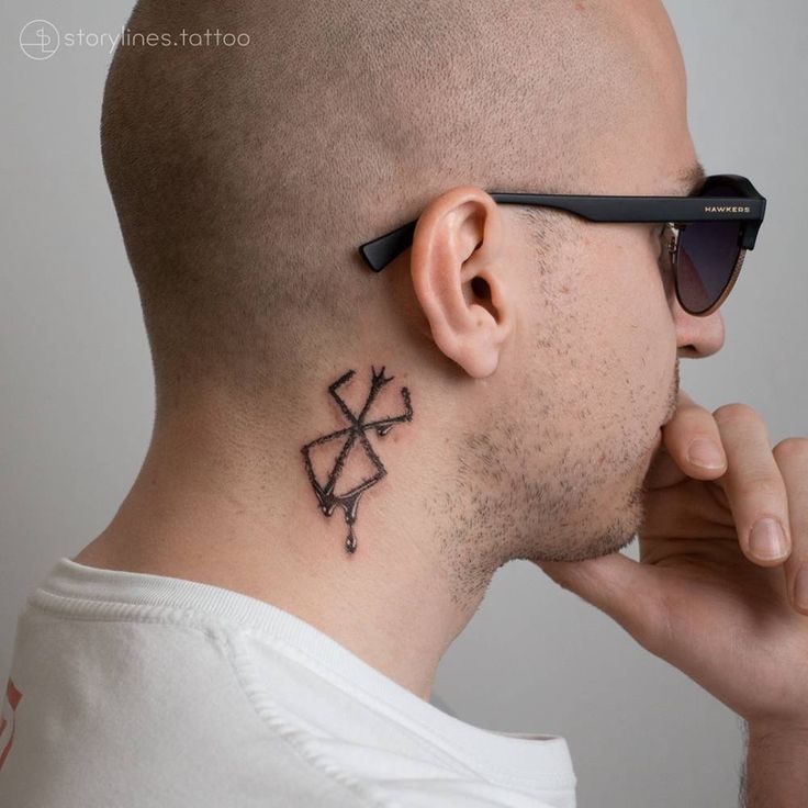 a man with a small tattoo on his neck