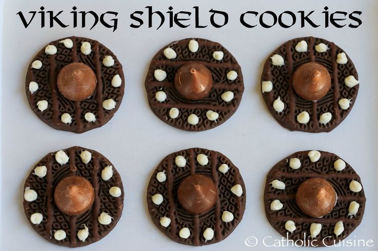 four chocolate covered cookies with white marshmallows in the middle and on top