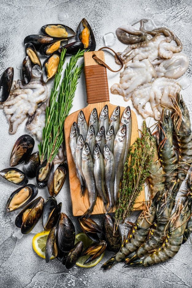 various seafoods are displayed on a cutting board