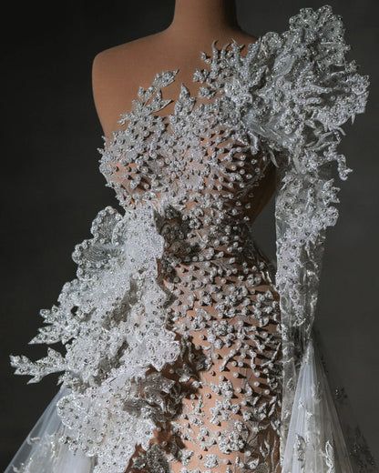 the back of a wedding dress with white flowers on it, and sheer lace overlays