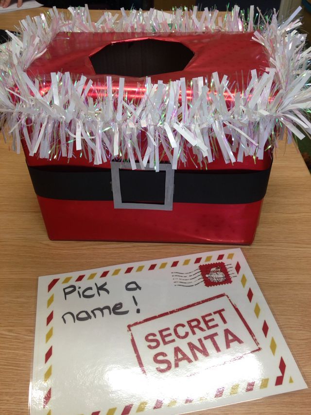 a santa's bag with some tinsel wrapped around it and a sign that says pick a name i secret santa