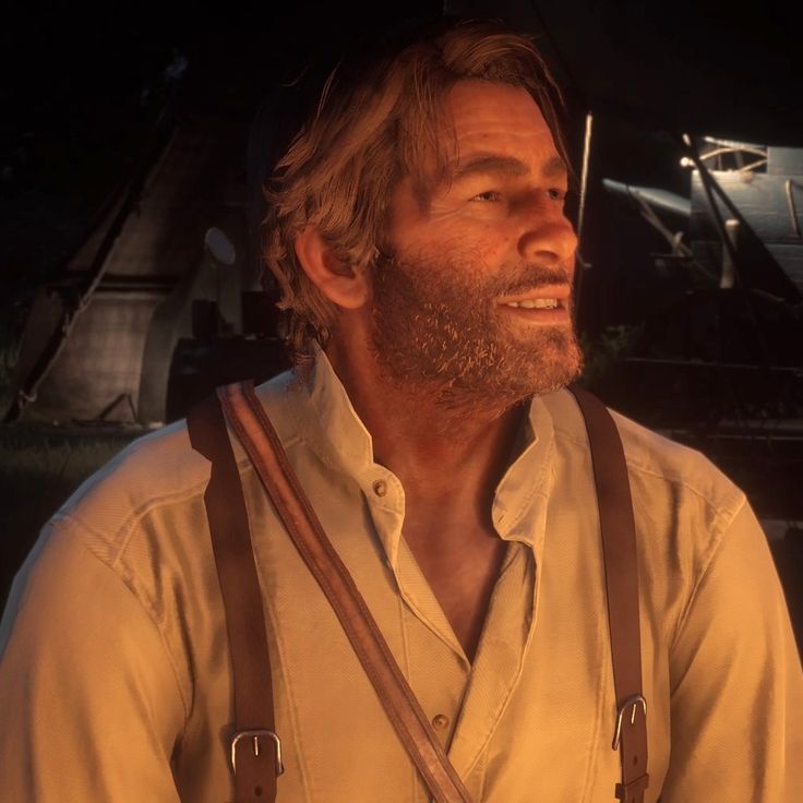 a man with long hair and beard wearing suspenders looking off into the distance while standing in front of an airplane