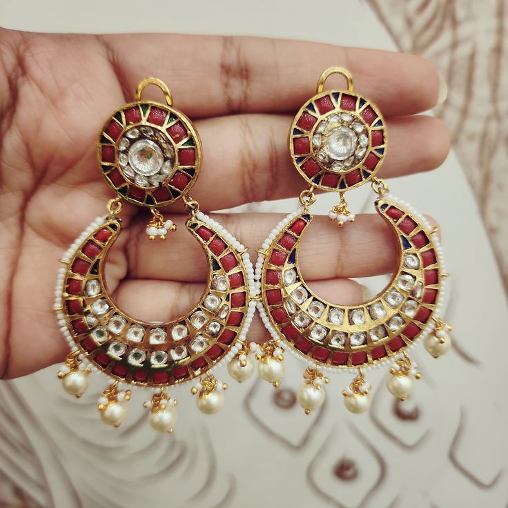 Adorn yourself with these Coral & Kundan Chandbali Earrings, crafted in gold foil. Featuring coral accents paired with Kundan work, these chandbalis blend traditional craftsmanship with timeless elegance. Perfect for special occasions, they add a regal touch to any ensemble. Length: 3" to 3.5" Material: 24Kt gold foil, lac Stones: Kundans, semi precious corals, semi precious pearls Kundan Chandbali, Coral Accents, Kundan Work, Chandbali Earrings, Pin Pendant, 24kt Gold, Pendant Rings, Natural Beads, Gold Foil