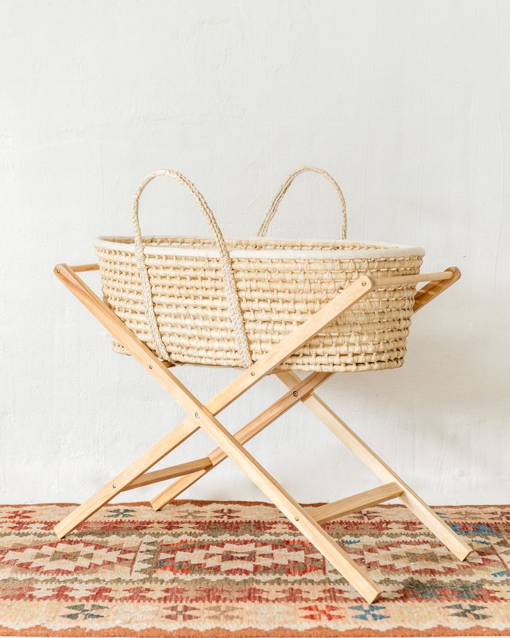 a woven basket with wooden handles on a rug