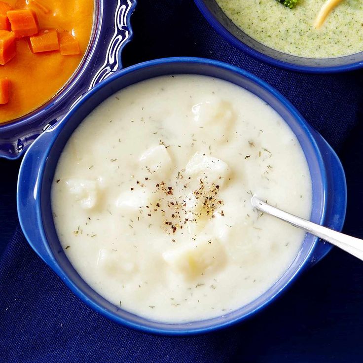 three bowls of soup with carrots and broccoli in them