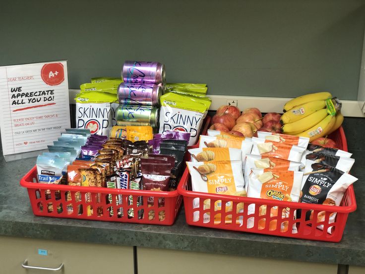 two red baskets filled with food sitting on top of a counter next to a sign