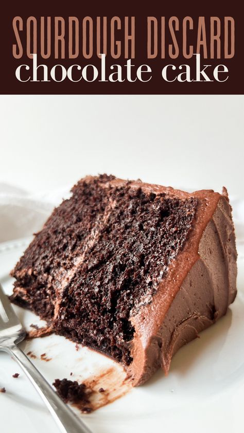 a slice of chocolate cake on a white plate with a fork in front of it