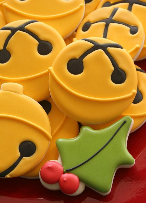 decorated cookies with smiley faces and holly decorations on a red platter, ready to be eaten