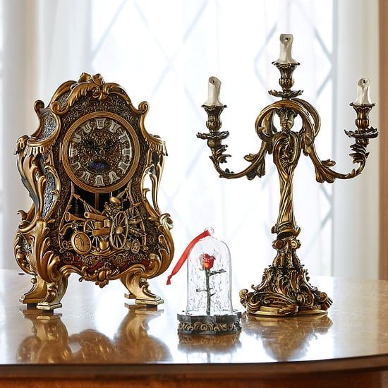 an ornate clock and candle holder on a table