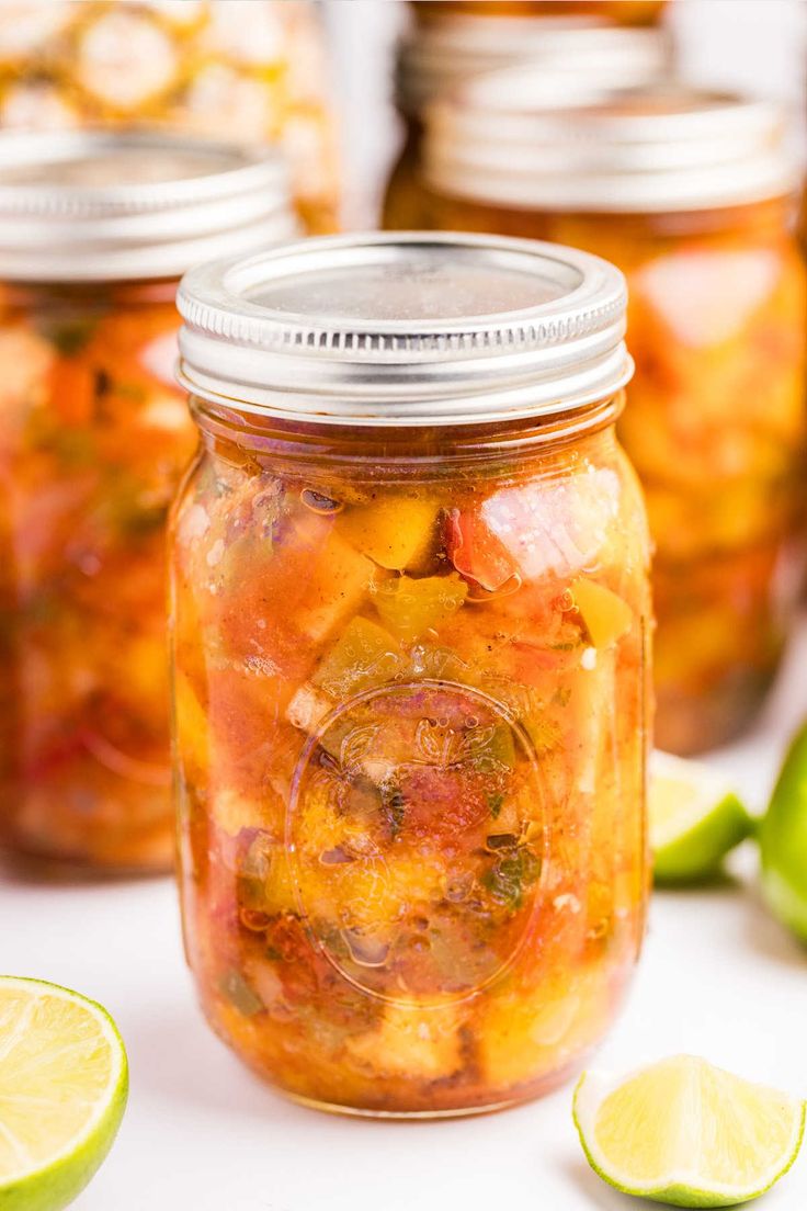 several jars filled with pickles and limes