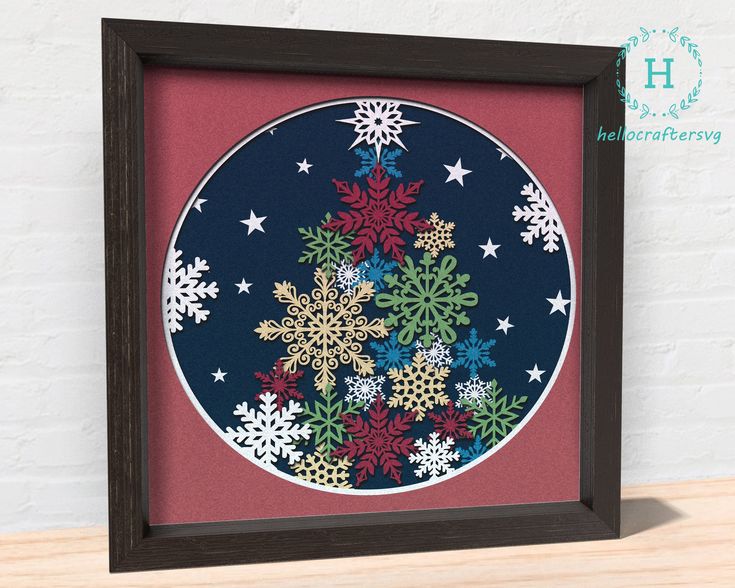 a framed paper art with snowflakes on it