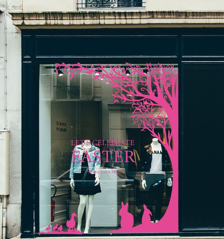 a store window with mannequins in front of it and a pink tree