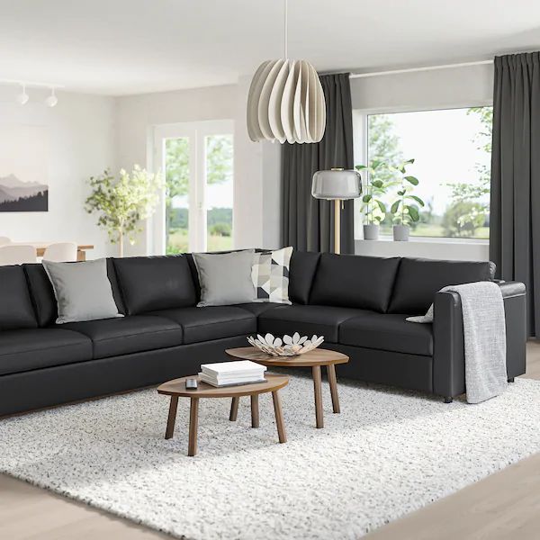 a living room filled with furniture and a white rug on top of a hard wood floor