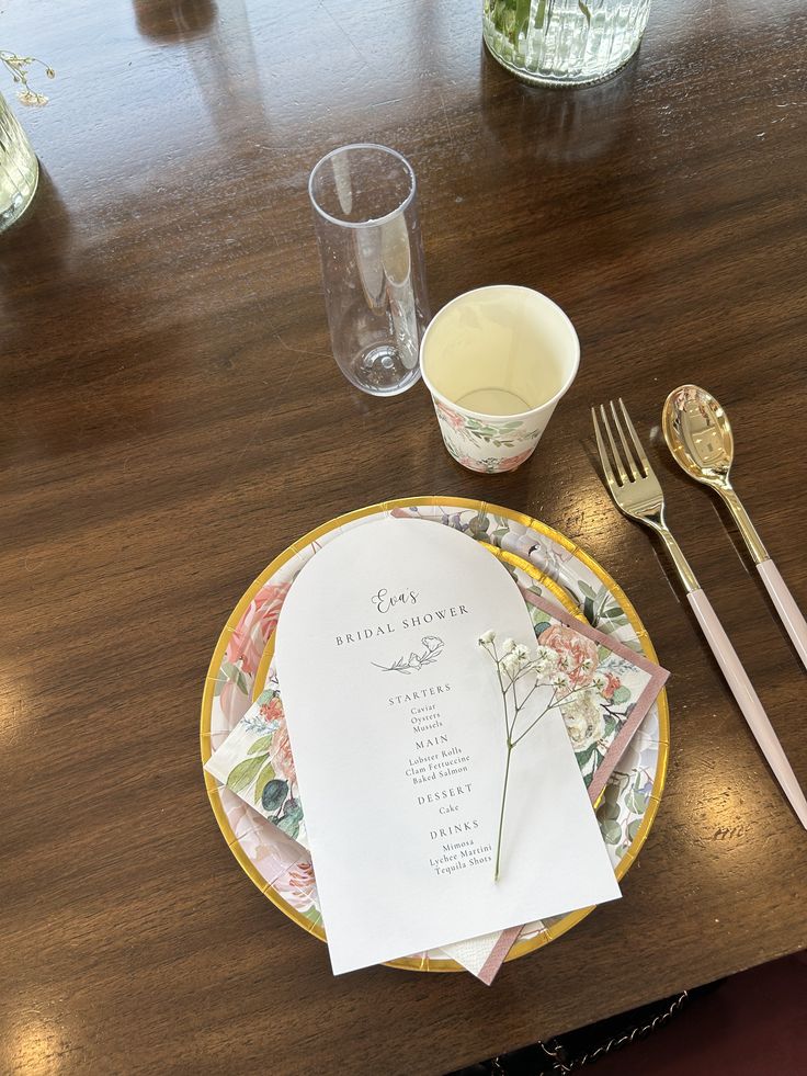 a place setting on a wooden table with silverware