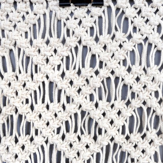 a white crochet doily with black handles