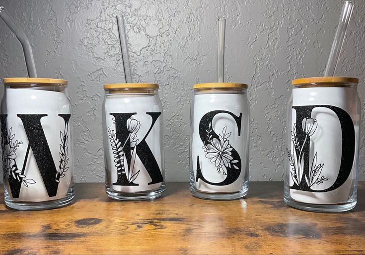 three mason jars with monogrammed letters and straws