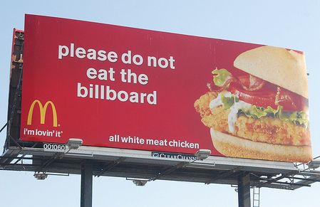 a billboard with a large sandwich on it's side that says, please do not eat the billboard