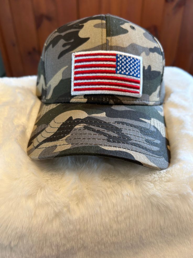 American Flag patch on a camo hat with adjustable closure Adjustable Hat For Veterans Day Outdoor Events, Memorial Day Outdoor Baseball Cap, One Size Fits Most Camouflage Snapback Hat, Outdoor Memorial Day Baseball Cap, Camouflage Trucker Baseball Cap With Flat Bill, Snapback Baseball Cap For Memorial Day Outdoor, Patriotic Hats For Veterans Day Outdoor Events, Camouflage Visor Snapback Hat For Outdoor, Camouflage Baseball Cap With Visor