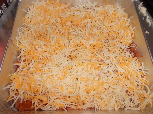 a casserole dish with cheese and meat in it