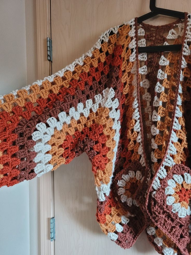 a crocheted jacket hanging on a door