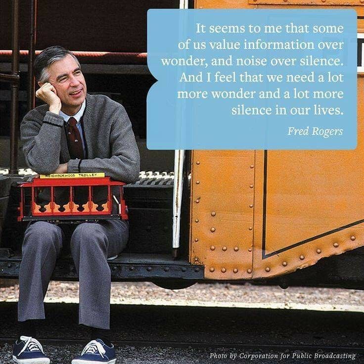 a man sitting on the side of a train holding a box with a quote above it