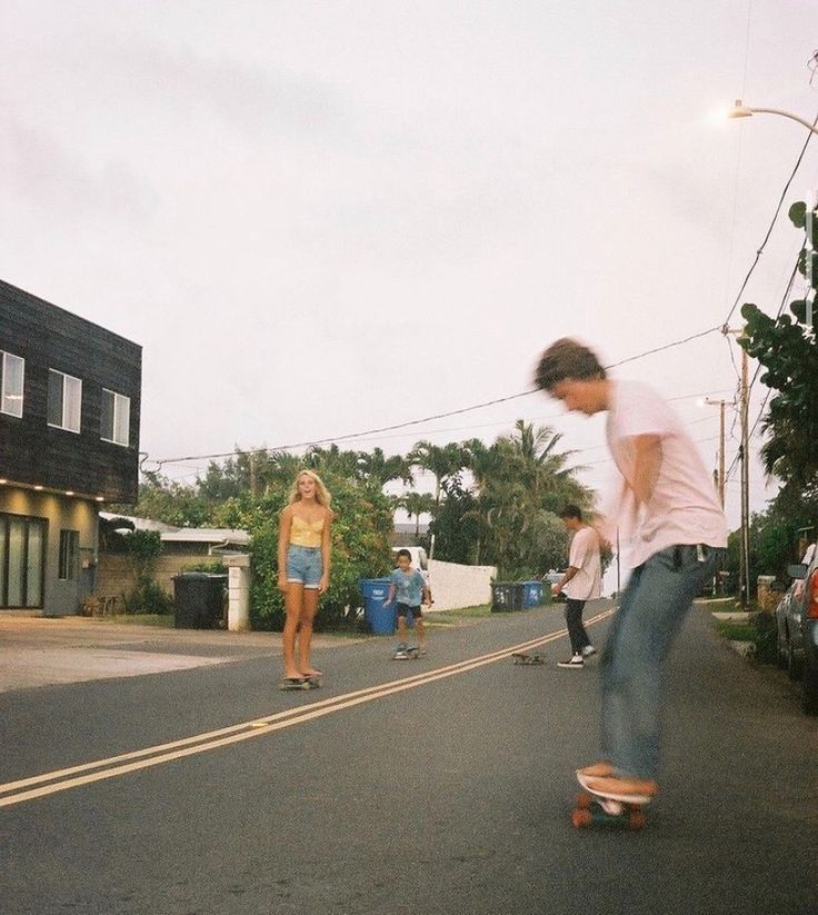 people are skateboarding down the street while one person is riding a skateboard behind them