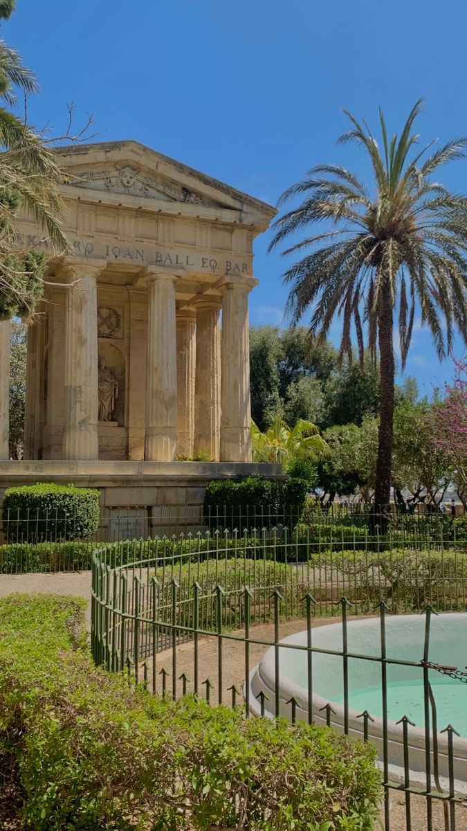 a fountain in front of a large building with columns