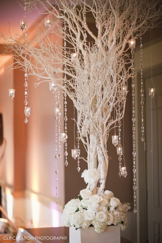 a vase filled with white flowers next to a chandelier hanging from the ceiling