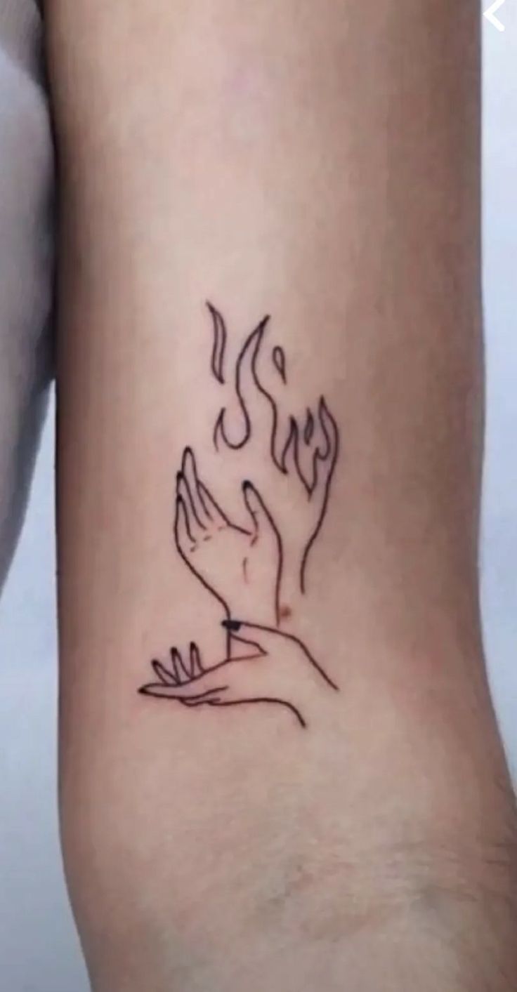 a woman's foot with a tattoo on it that has two hands holding something