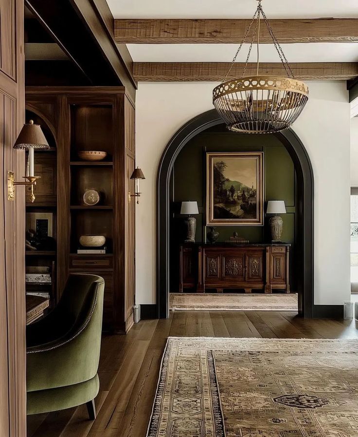 a living room filled with furniture and a chandelier hanging from the ceiling next to a doorway